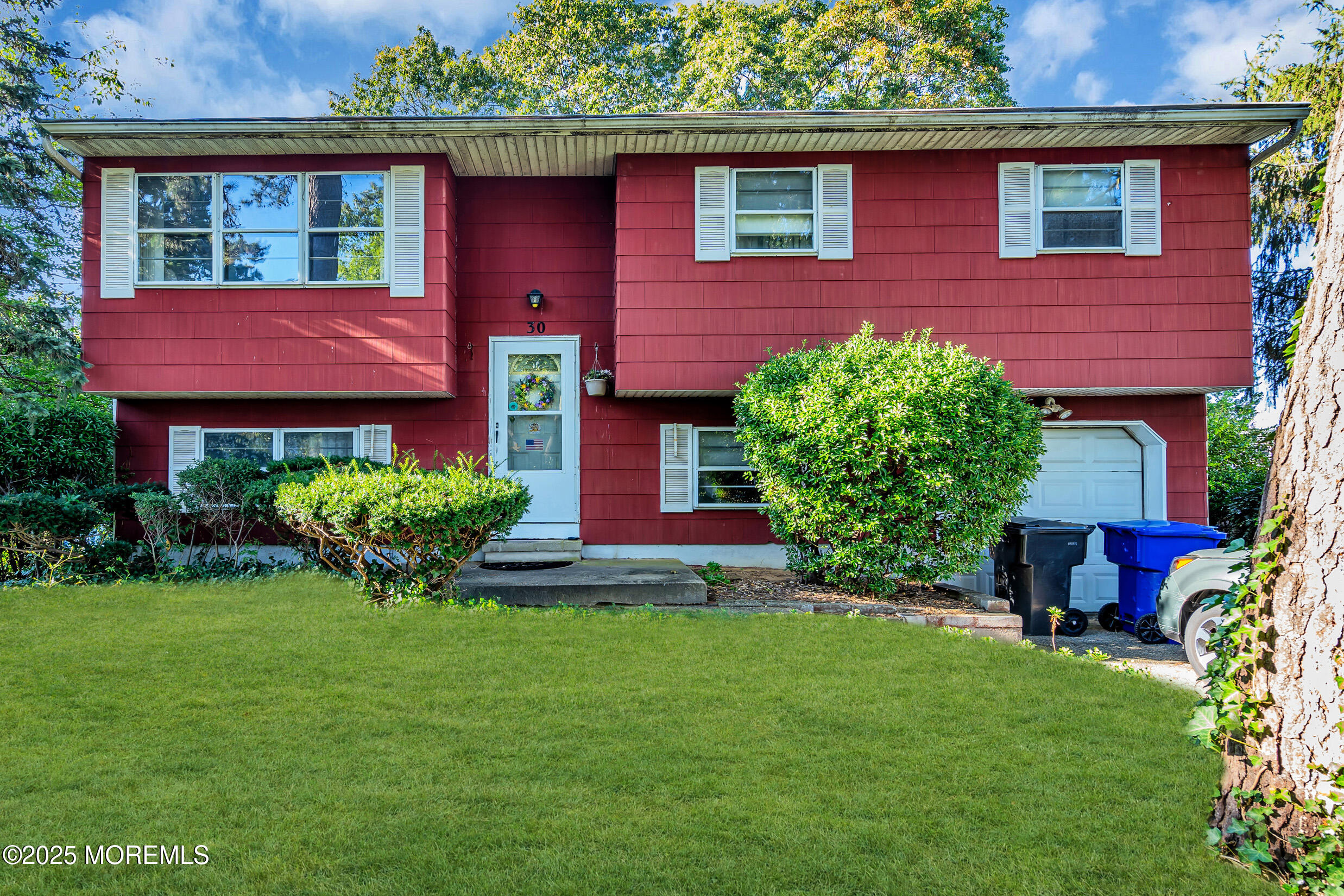 a front view of a house with yard and green space
