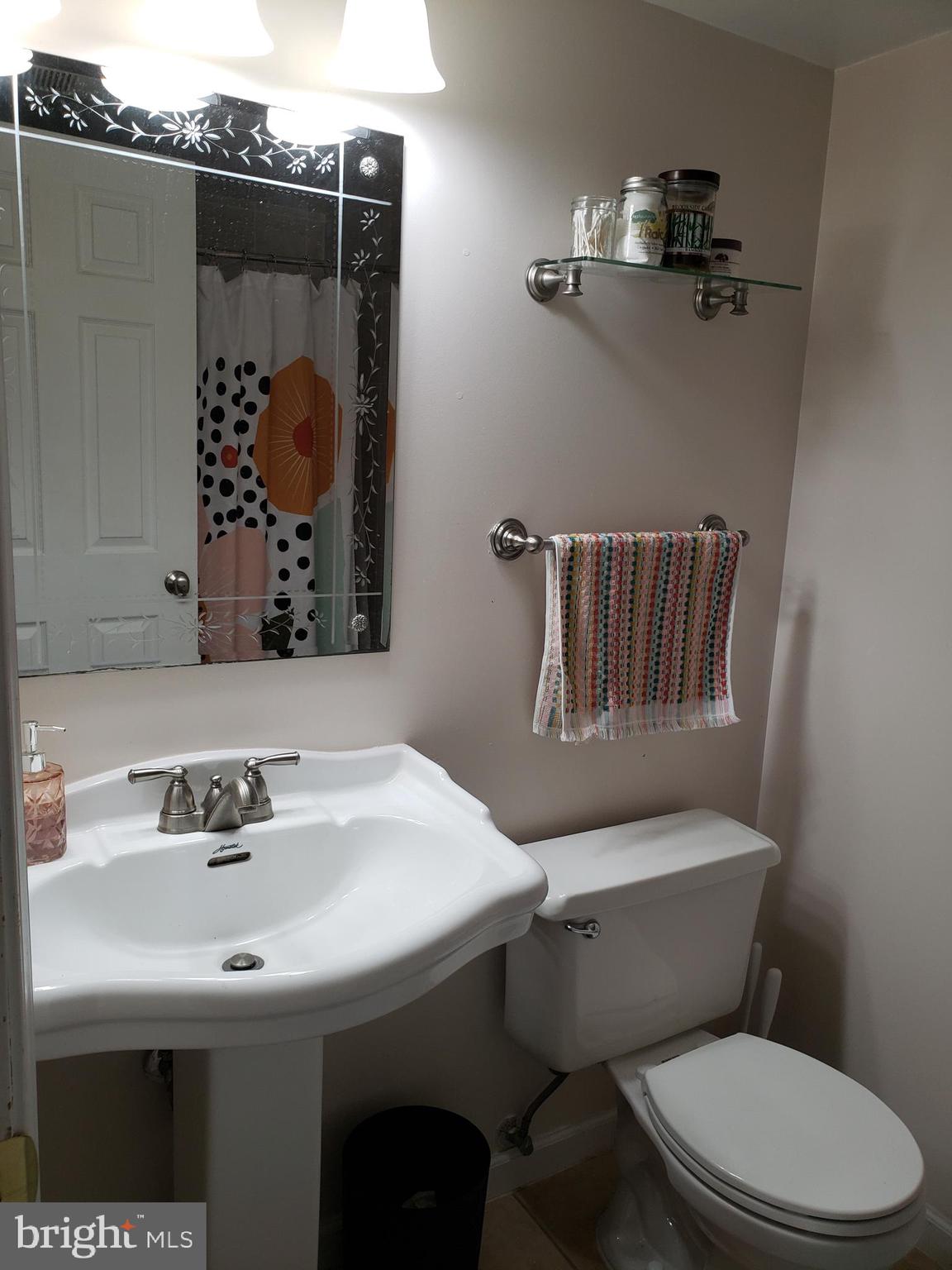 8639 Victoria Road Springfield, VA 22151 - Photo 15 of 17 a bathroom with a sink toilet and mirror