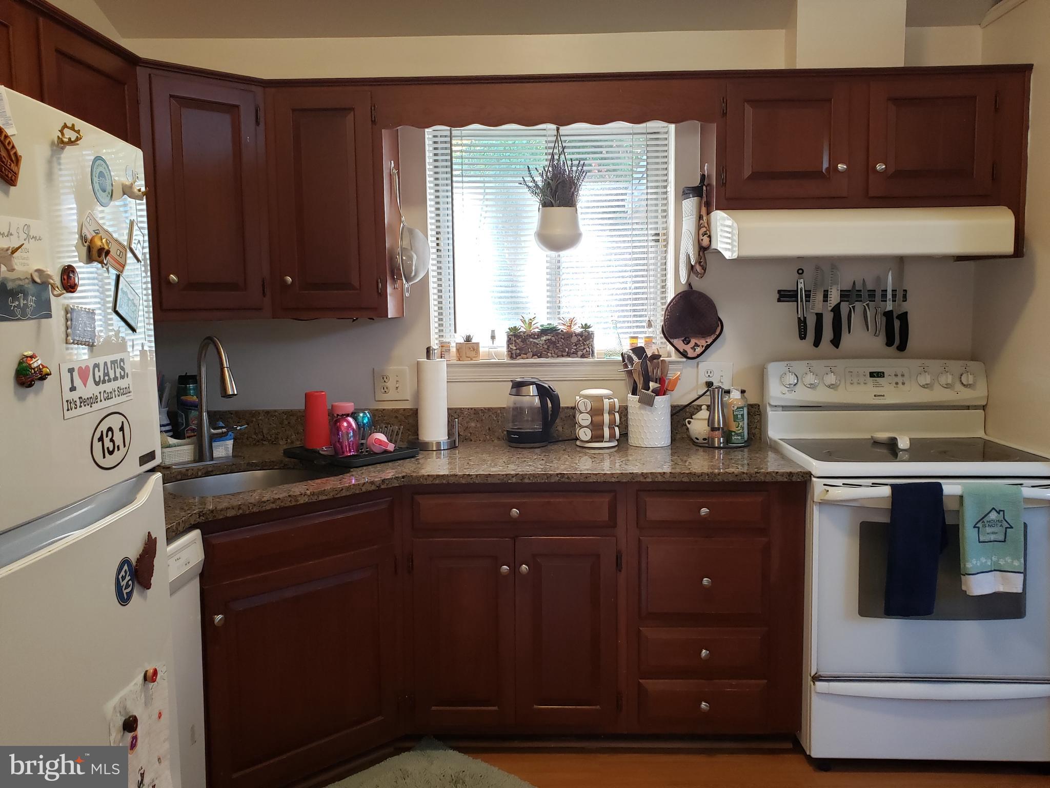 8639 Victoria Road Springfield, VA 22151 - Photo 5 of 17 a kitchen with stainless steel appliances a sink dishwasher and cabinets with wooden floor