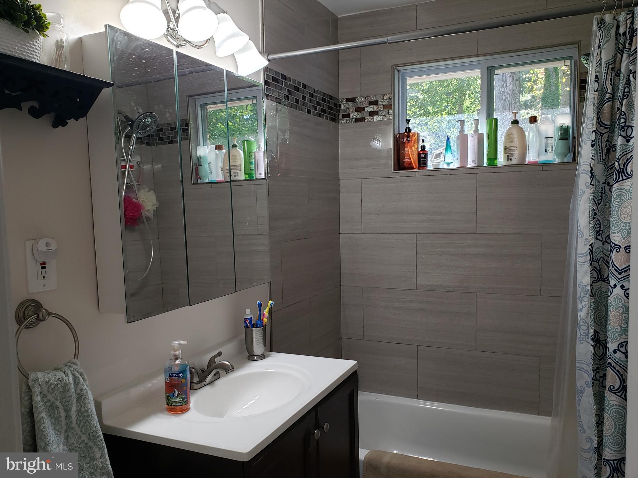 8639 Victoria Road Springfield, VA 22151 - Photo 7 of 17 a bathroom with a sink vanity tub and shower
