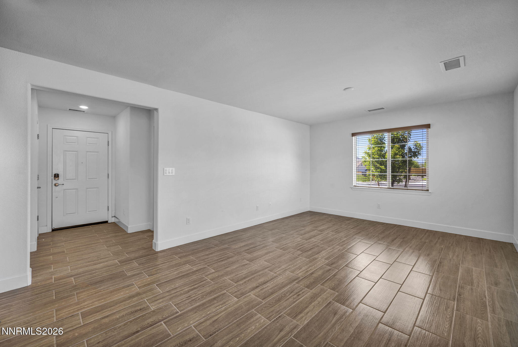 7181 Saddlehorn Road Carson City, NV 89701 - Photo 10 of 62 an empty room with wooden floor windows and entrance