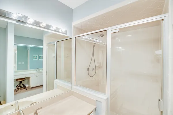 a bathroom with a glass shower door and a mirror