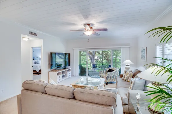 a living room with furniture a flat screen tv and a large window