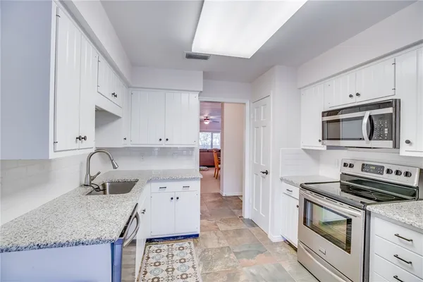 a kitchen with stainless steel appliances granite countertop a sink stove and cabinets