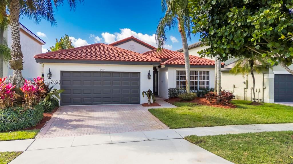 2972 Southwest 174th Avenue Miramar, FL 33029 - Photo 1 of 55 a front view of a house with a yard and garage