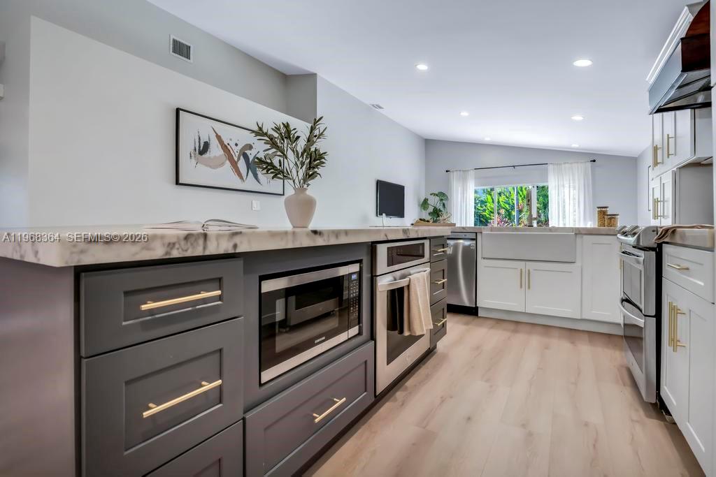 2972 Southwest 174th Avenue Miramar, FL 33029 - Photo 6 of 55 a kitchen with stainless steel appliances granite countertop a stove top oven a sink dishwasher and a refrigerator with wooden floor