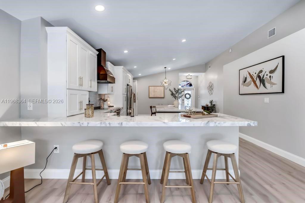 2972 Southwest 174th Avenue Miramar, FL 33029 - Photo 10 of 55 a kitchen with stainless steel appliances granite countertop a dining table chairs and wooden floor