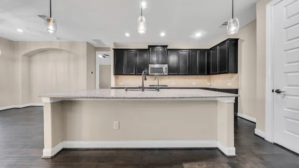 a view of kitchen with stainless steel appliances granite countertop wooden cabinets and a sink