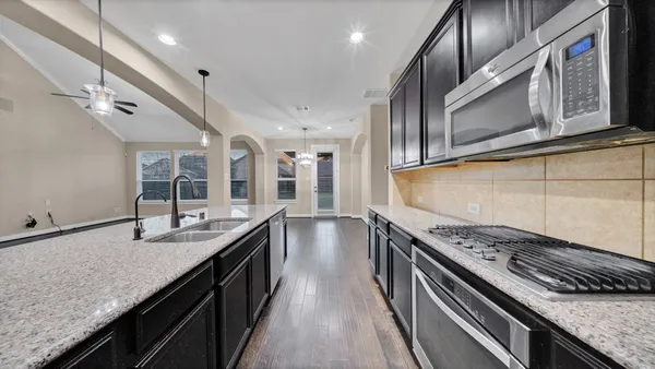 a kitchen with stainless steel appliances granite countertop a sink and stove