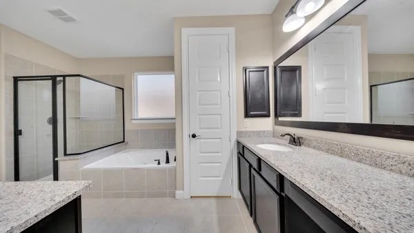 a spacious bathroom with a granite countertop double vanity sink and mirror