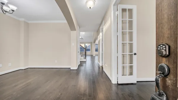a view of a hallway with wooden floor and staircase