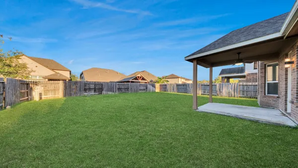 a view of a big house with a big yard potted plants and large tree