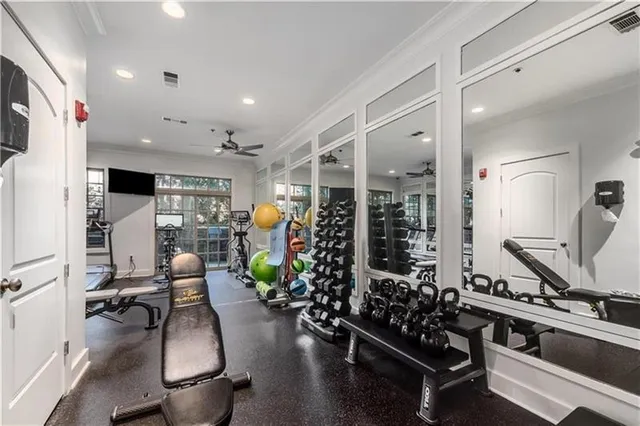 a room with lots of potted plants kitchen view and a refrigerator