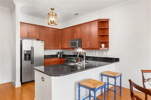 a kitchen with stainless steel appliances granite countertop a sink refrigerator and cabinets