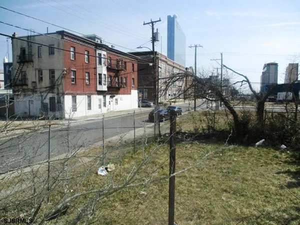a view of a town with large trees and barn in the background