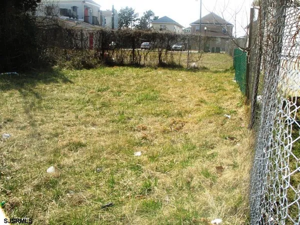 a view of a yard with wooden fence