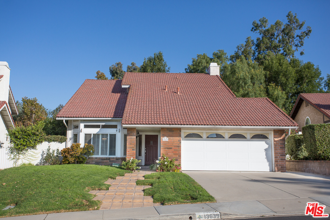 13639 Bear Valley Road Moorpark, CA 93021 - Photo 1 of 25 a front view of a house with a yard and garage