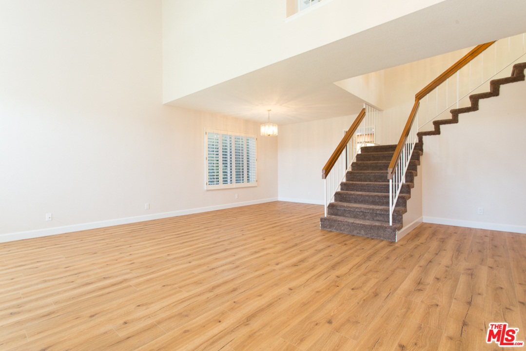 13639 Bear Valley Road Moorpark, CA 93021 - Photo 5 of 25 a view of an empty room with wooden floor and stairs