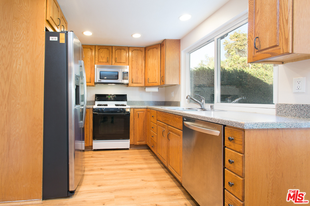 13639 Bear Valley Road Moorpark, CA 93021 - Photo 10 of 25 a kitchen with stainless steel appliances granite countertop a stove a sink and a refrigerator