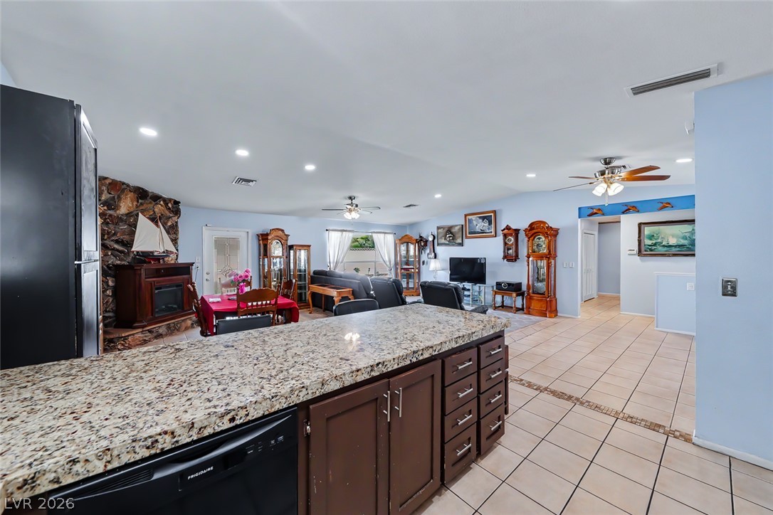 3107 Trueno Road Henderson, NV 89014 - Photo 16 of 37 Well-lit living area and kitchen with recessed lighting, tile flooring, and a granite island for comfortable living.