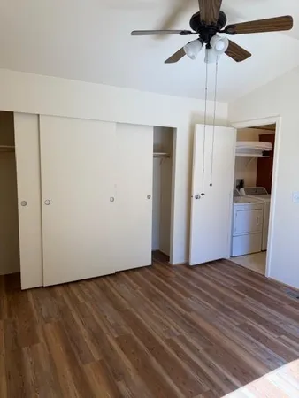 an empty room with closet and a ceiling fan