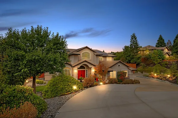 a front view of a house with a yard and tree s