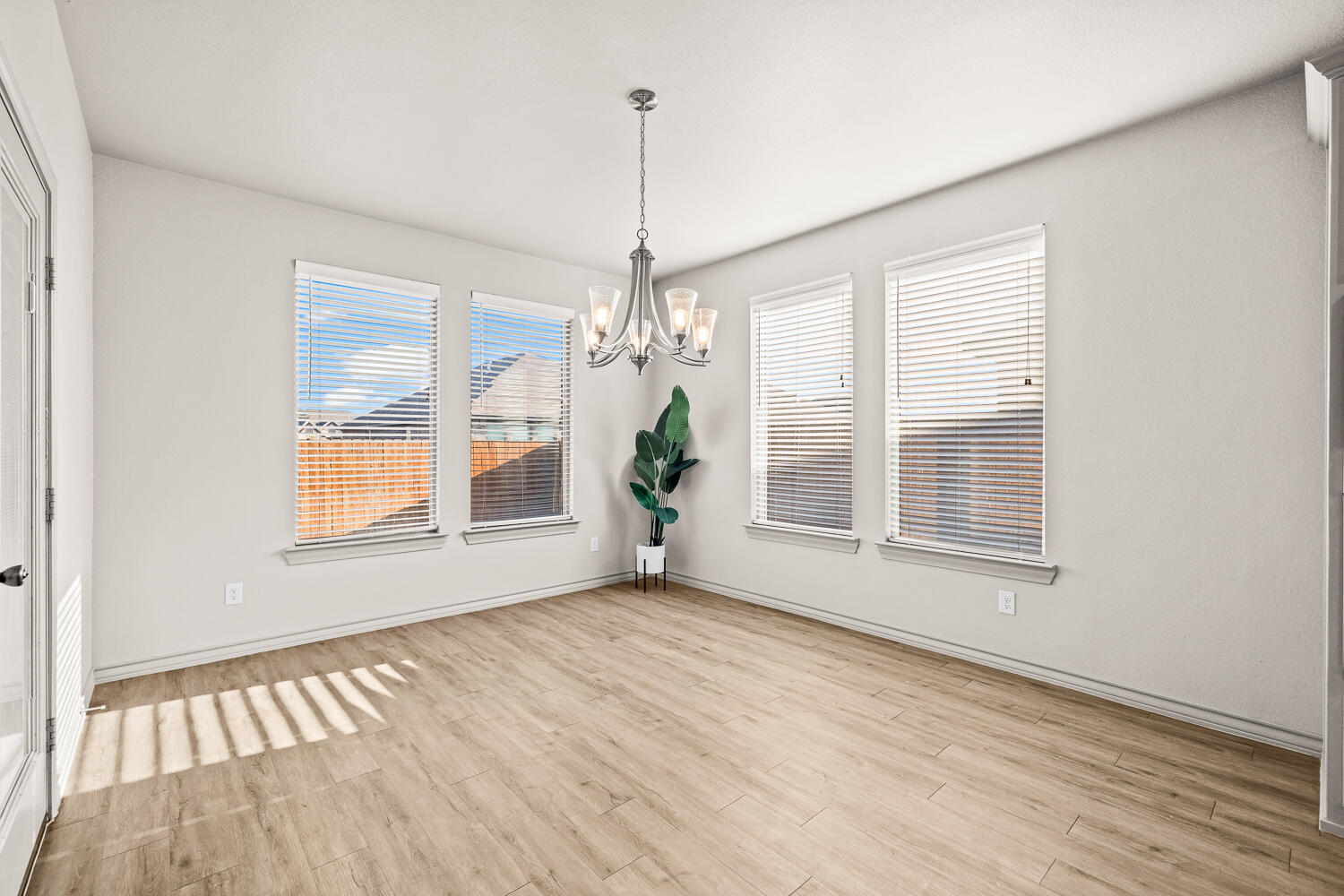 7613 61st Street Lubbock, TX 79407 - Photo 12 of 37 a view of an empty room with wooden floor and a window