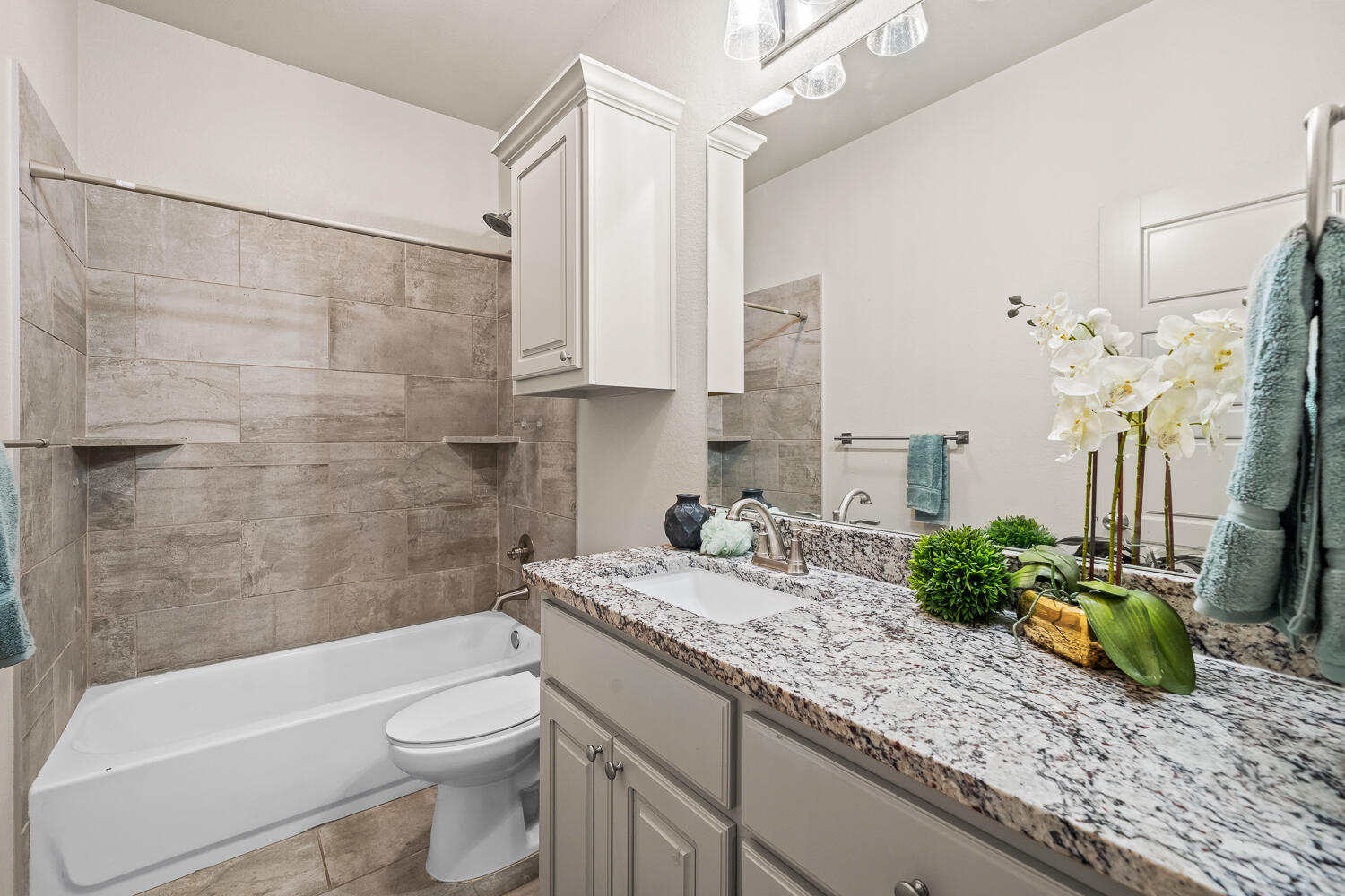 7613 61st Street Lubbock, TX 79407 - Photo 31 of 37 a bathroom with a granite countertop sink a toilet and bathtub