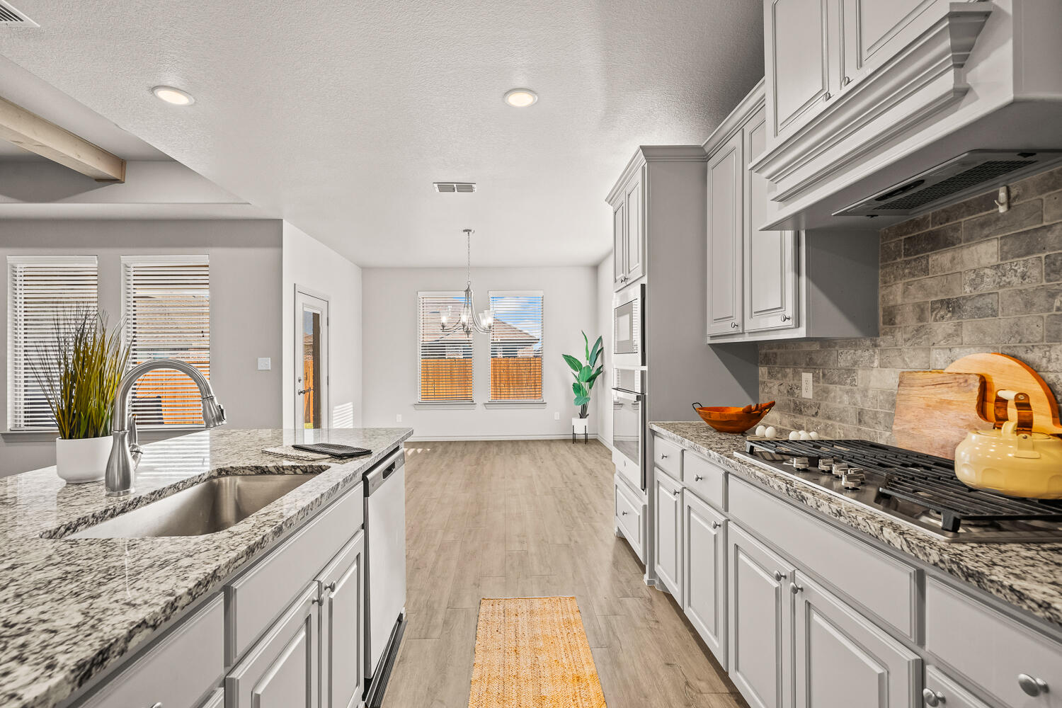 7613 61st Street Lubbock, TX 79407 - Photo 9 of 37 a kitchen with granite countertop a sink a stove and cabinets