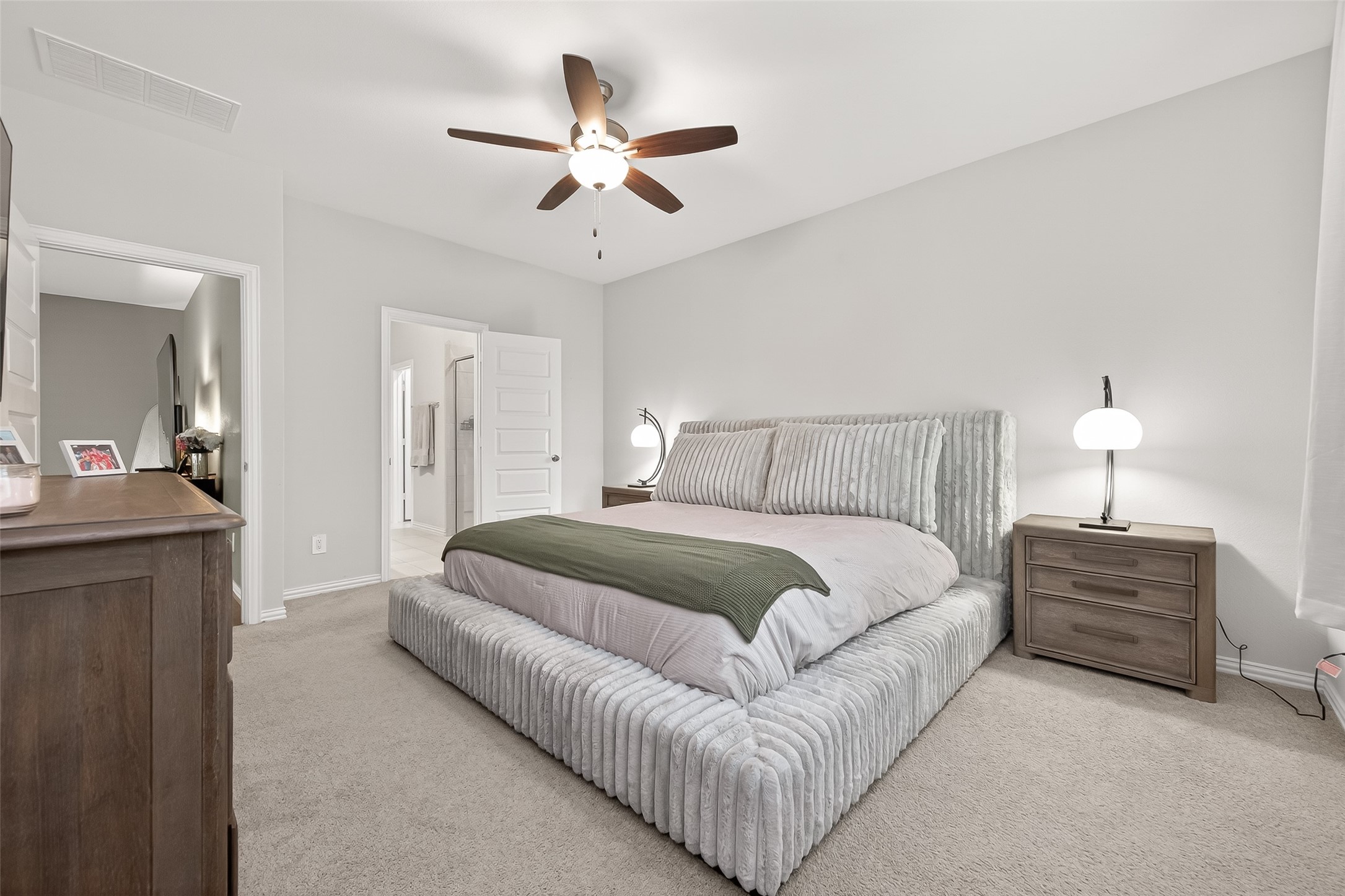 218 Skybranch Court Conroe, TX 77304 - Photo 15 of 50 a bedroom with a large bed and a chandelier