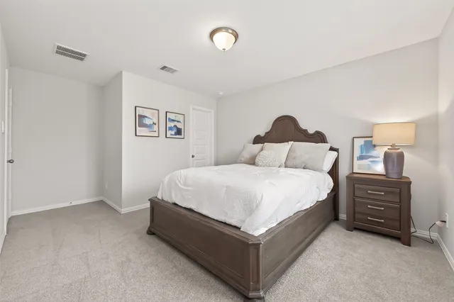 a spacious bedroom with a bed and cabinet