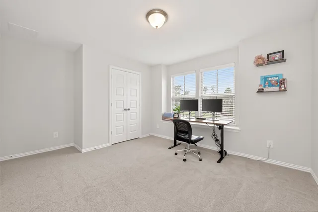 a view of a workspace with furniture and a window