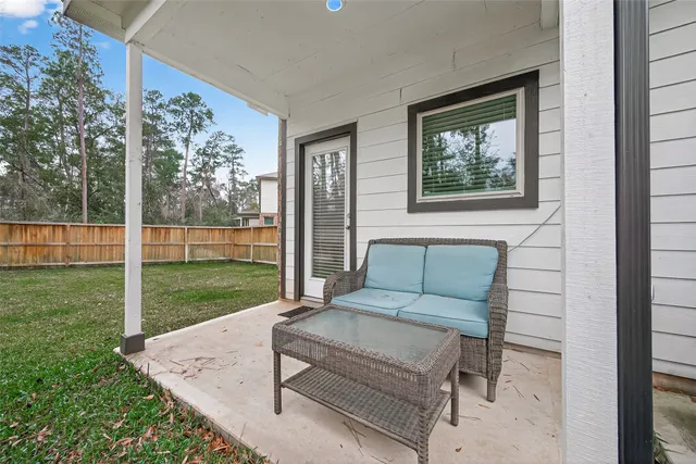 a view of a two couches in the patio with a small yard