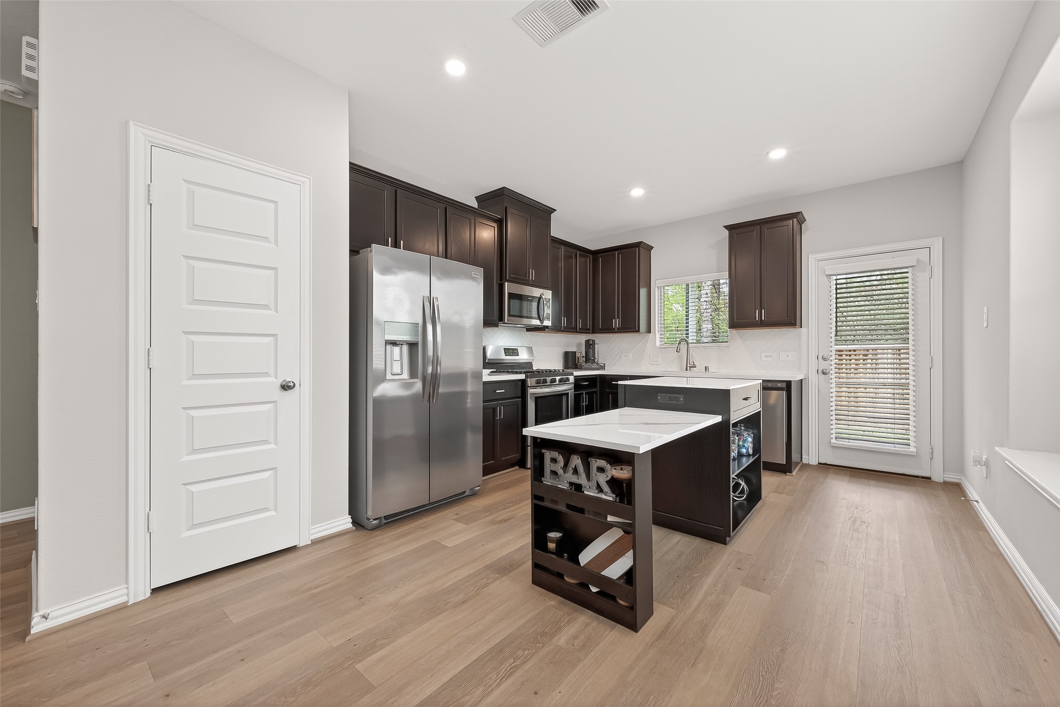 218 Skybranch Court Conroe, TX 77304 - Photo 10 of 50 a kitchen with a refrigerator a sink dishwasher and a stove with wooden floor
