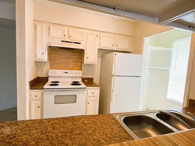 a kitchen with a stove a refrigerator and a sink