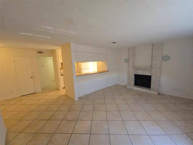 an empty room with windows and fireplace