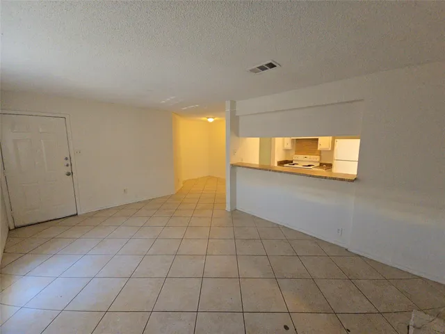 a view of a livingroom with an empty space and a window