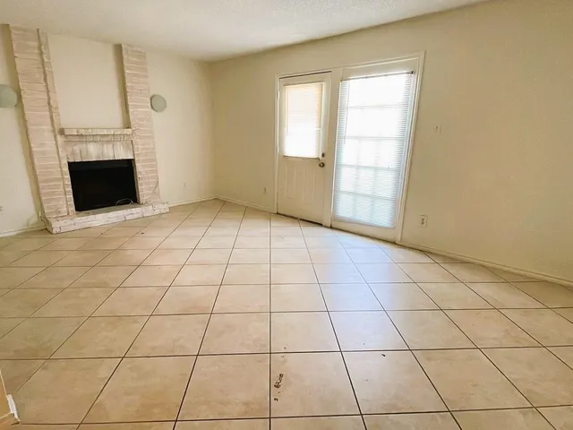 a view of empty room with wooden floor and fireplace