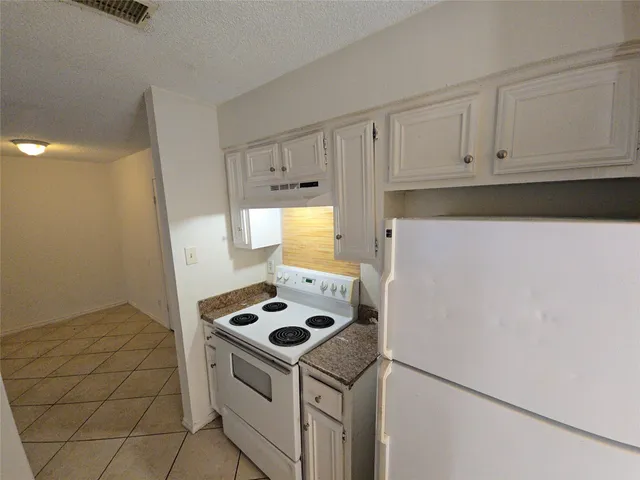 a kitchen with a stove and a refrigerator