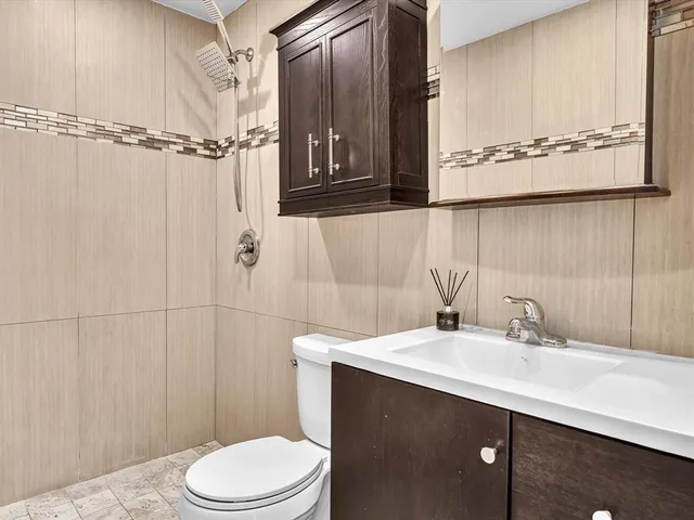 a bathroom with a sink a toilet and shower