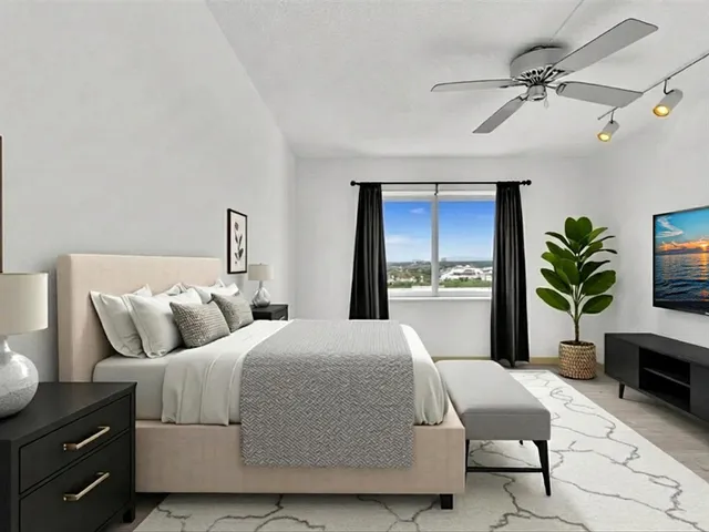 a bedroom with a large bed and a potted plant