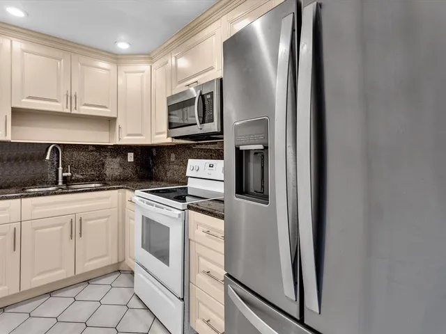 a kitchen with white cabinets and white appliances