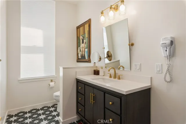 a view of a dining room with furniture one side kitchen view and wooden floor