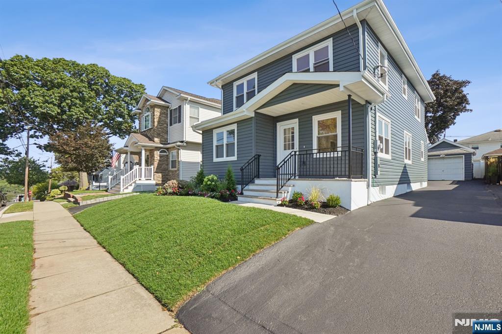 271 North Avenue Wood-Ridge, NJ 07075 - Photo 1 of 18 a front view of a house with a yard and potted plants
