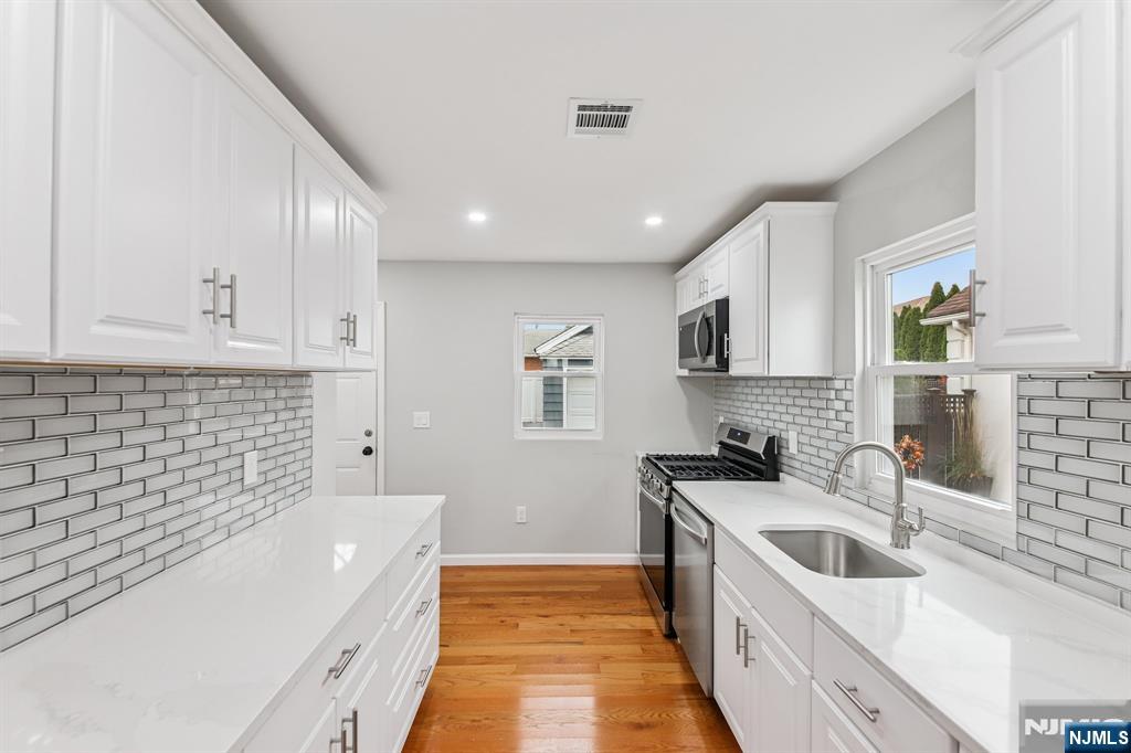 271 North Avenue Wood-Ridge, NJ 07075 - Photo 3 of 18 a large kitchen with stainless steel appliances granite countertop a sink and cabinets