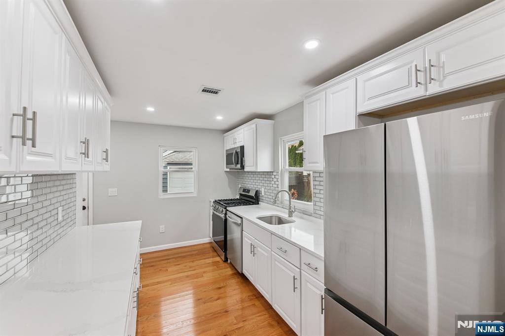 271 North Avenue Wood-Ridge, NJ 07075 - Photo 4 of 18 a kitchen with stainless steel appliances a refrigerator sink and cabinets