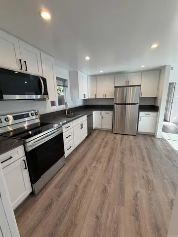 a kitchen with a sink a stove and cabinets