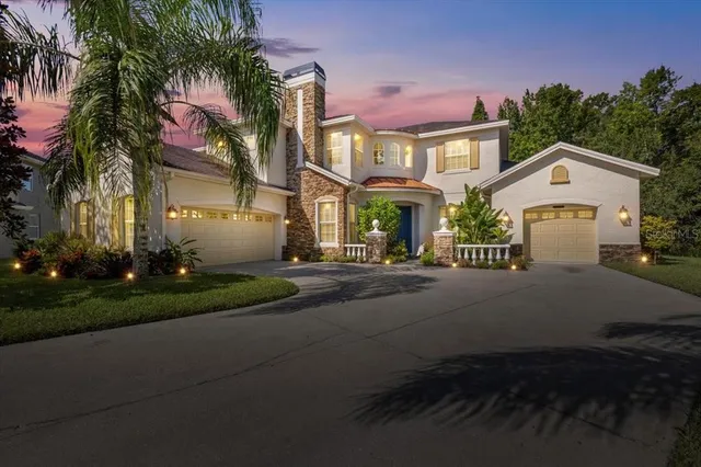 a front view of a house with a yard and tree s