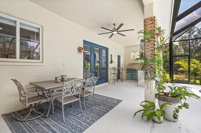 a dining room with furniture potted plants and wooden floor