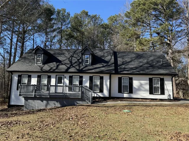 a front view of a house with large trees